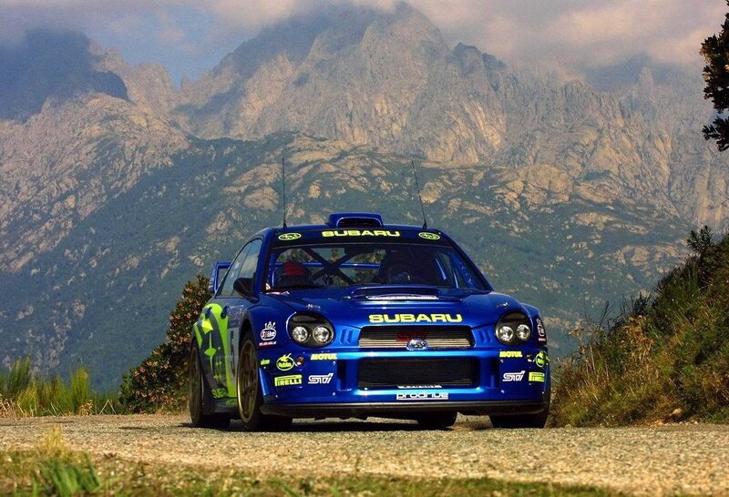 Blue Subaru rally car on mountain road