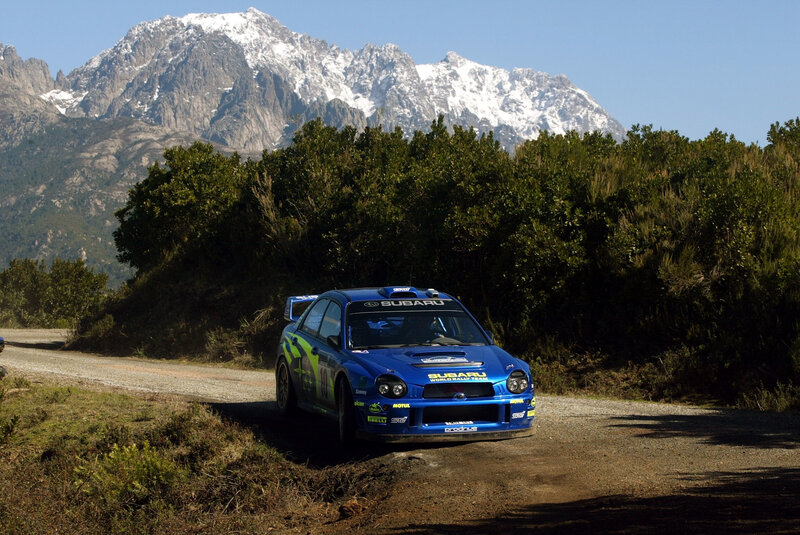 Blue Subaru rally car on mountain road