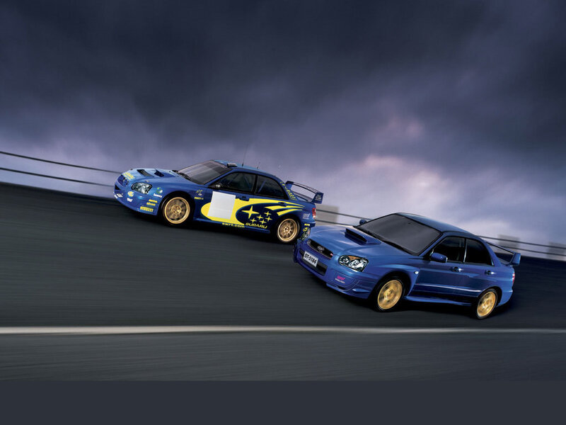 Blue Subaru rally cars on track