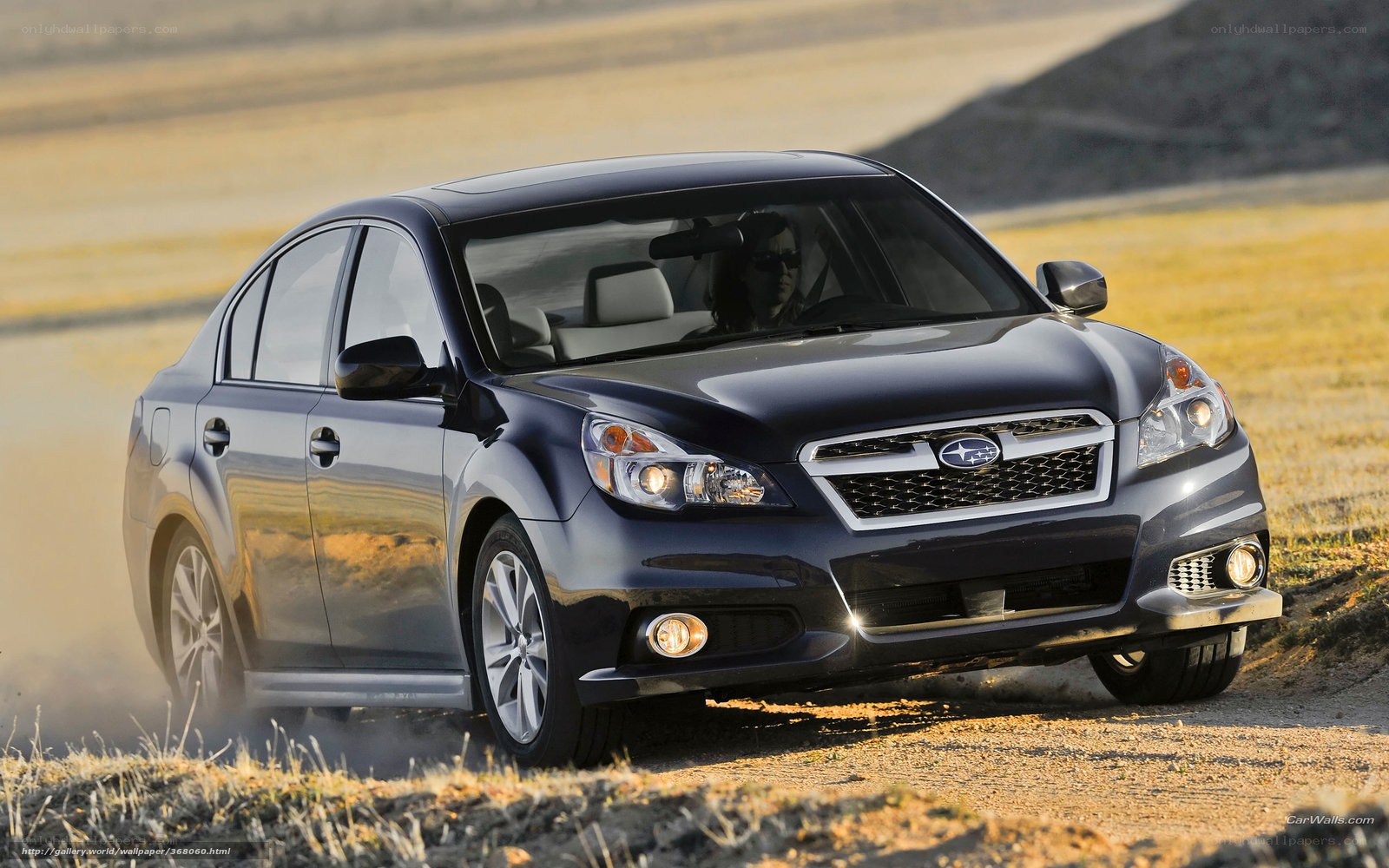 blue subaru sedan on dirt road