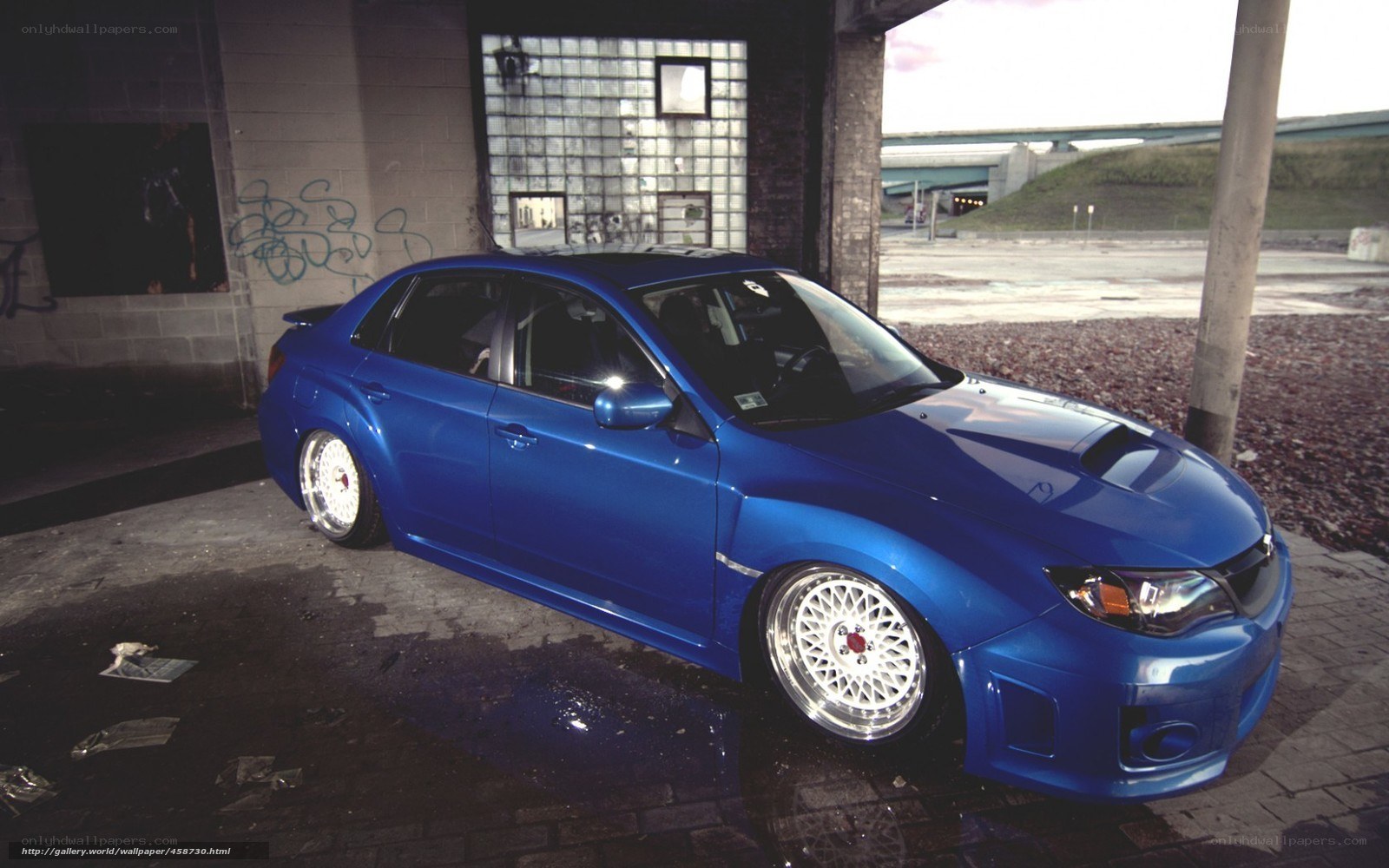 blue subaru wrx parked under bridge