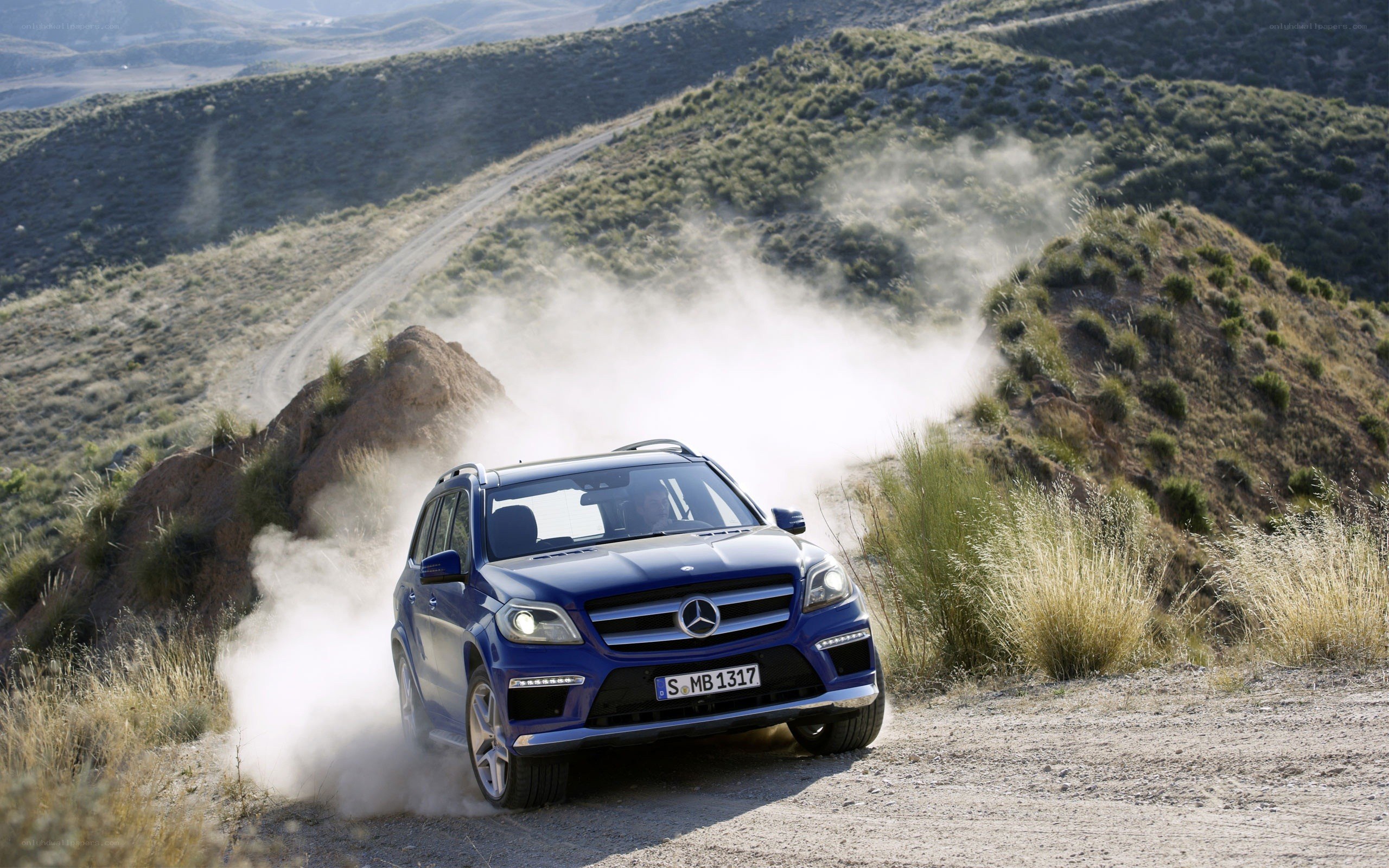 Blue SUV on dusty mountain road