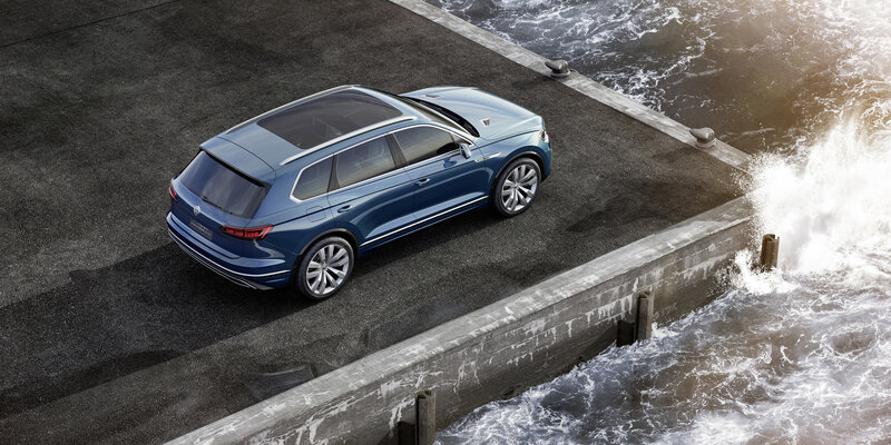Blue SUV on pier by ocean