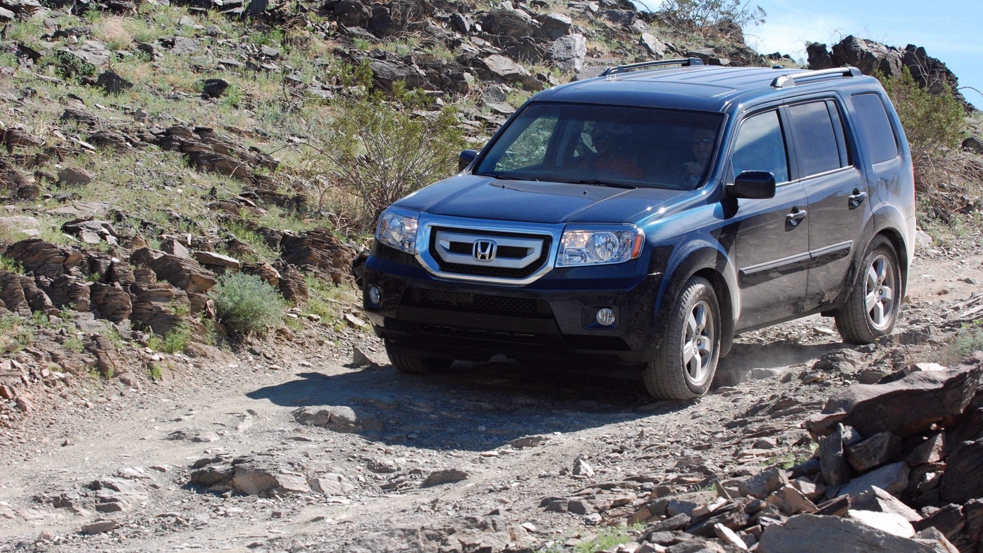 Blue SUV on rocky trail