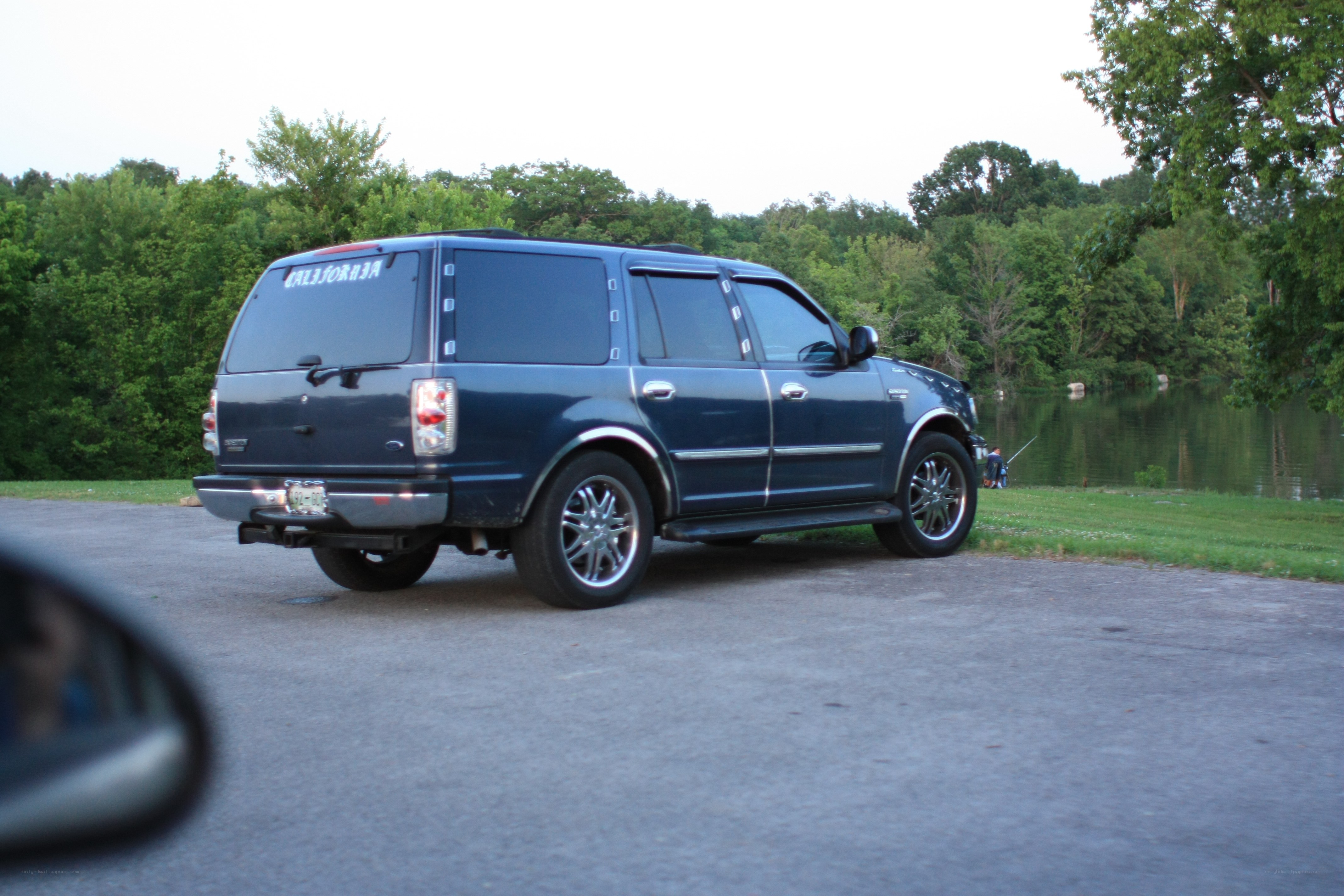 Blue SUV parked by a lake