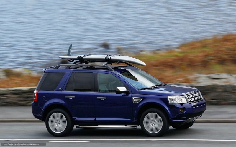 Blue SUV with surfboard on roof
