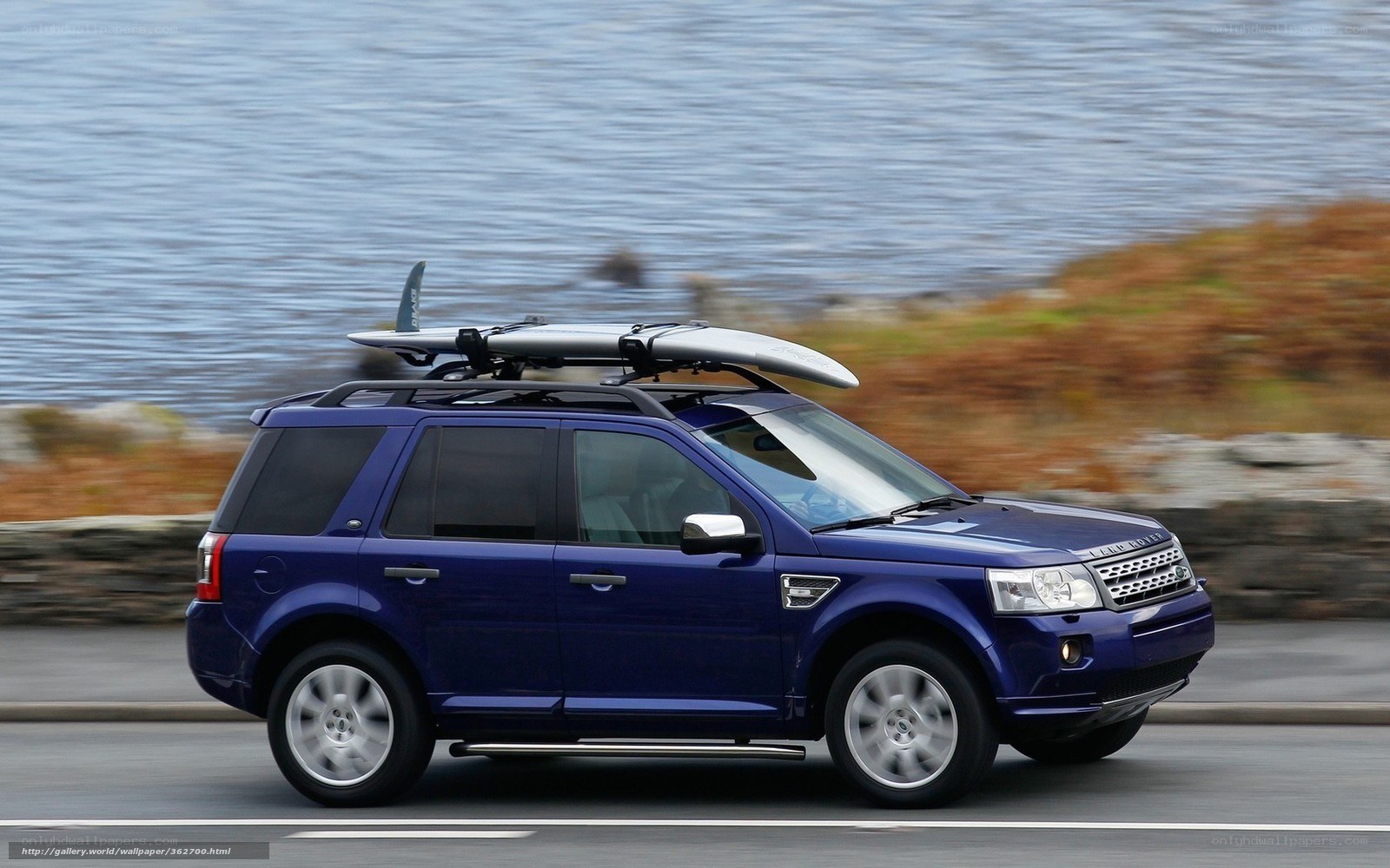 Blue SUV with surfboard on roof