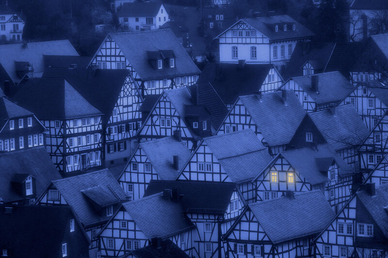 blue-tinted village rooftops at dusk
