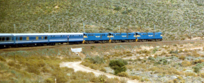 Blue train in a desert landscape