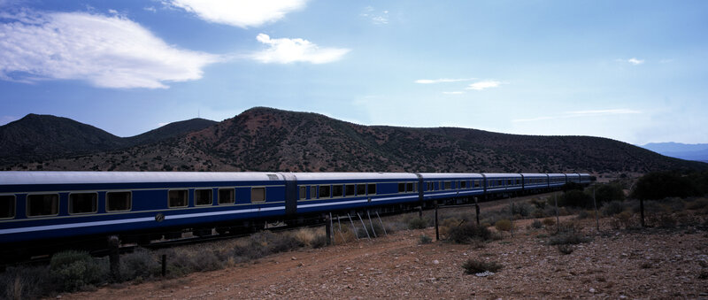 Blue train in desert landscape