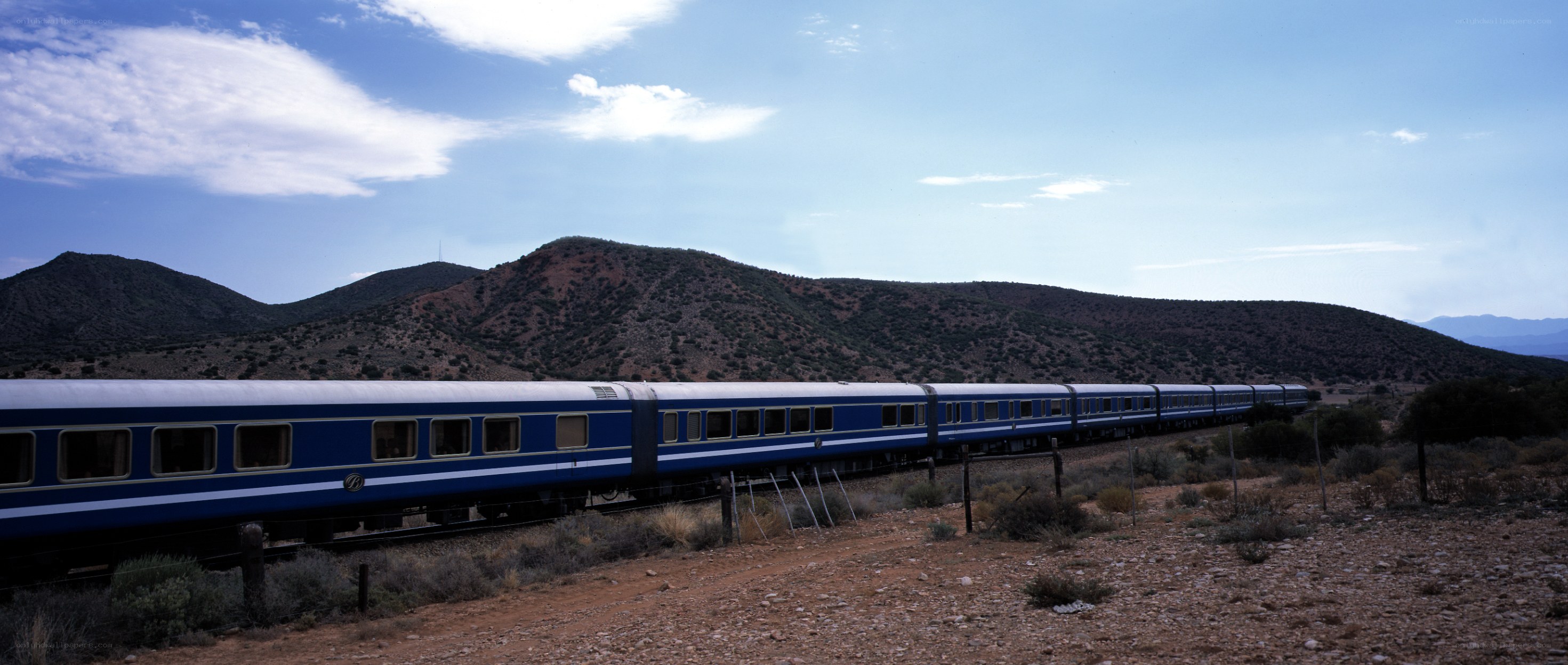 Blue train in desert landscape