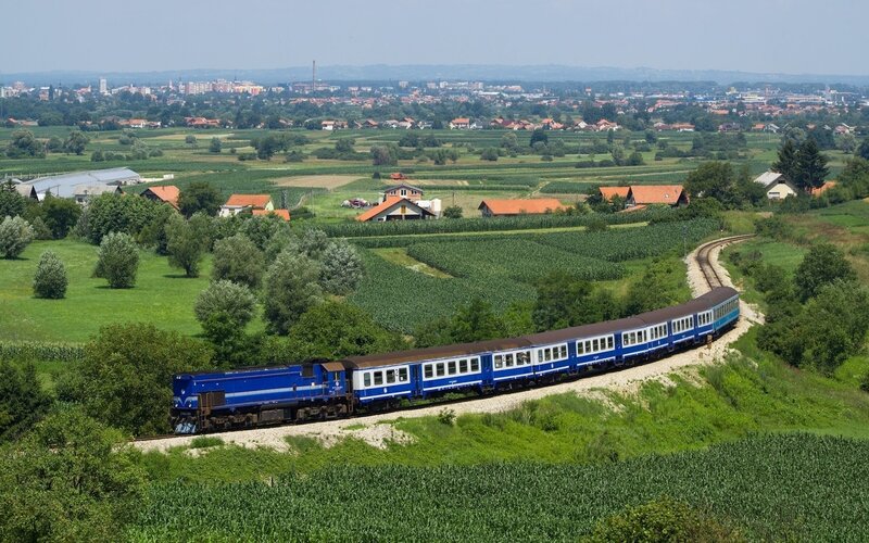 Blue train in rural landscape