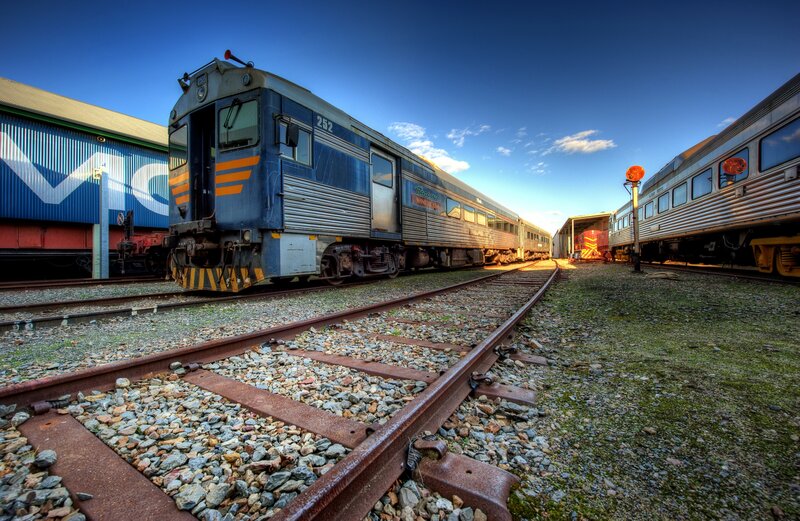 Blue Train on Tracks — Dramatic, Sunset