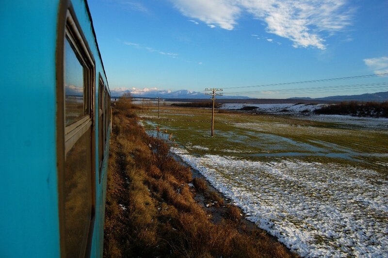 blue train passing snowy field