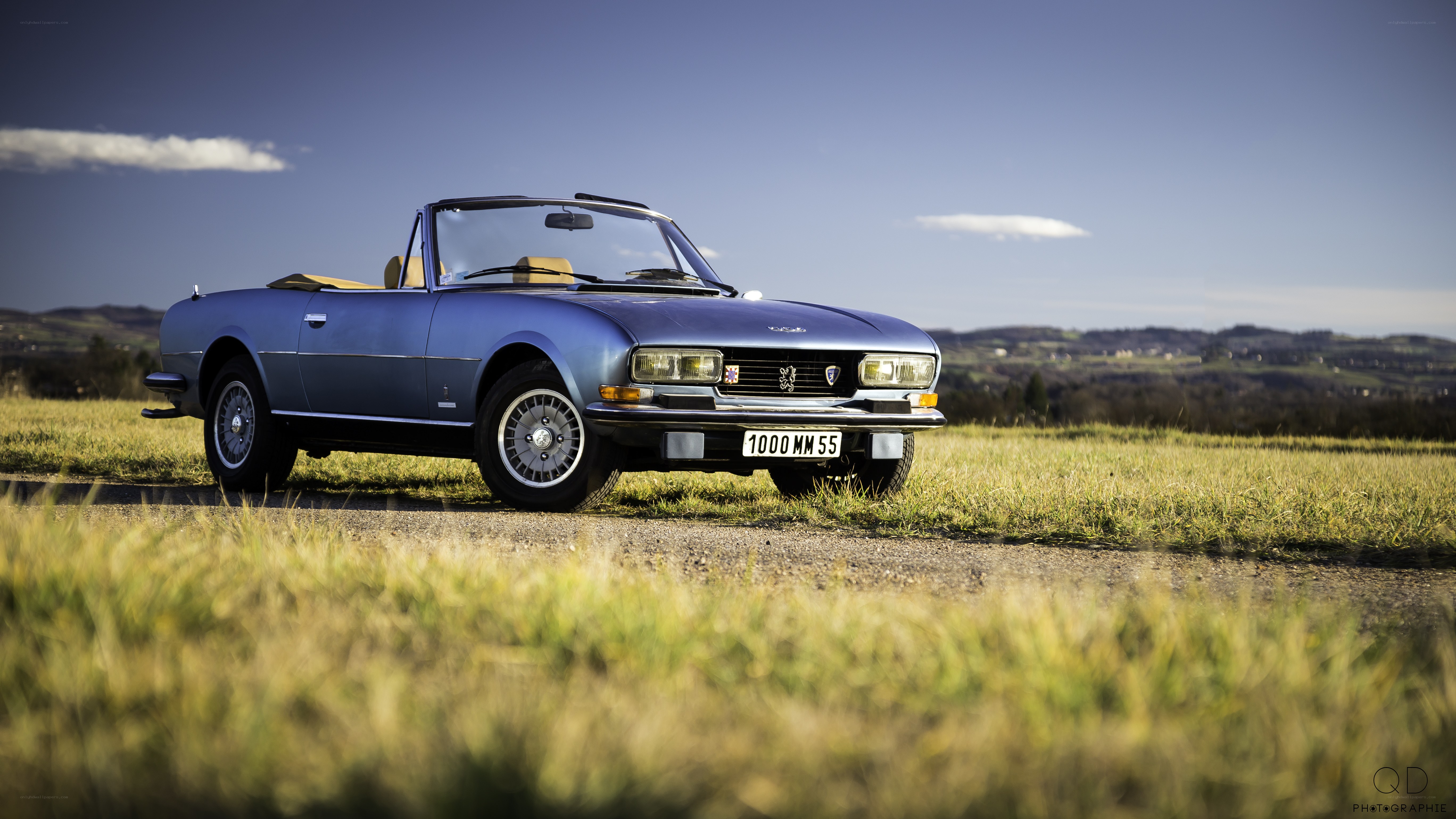 Blue vintage convertible on a country road