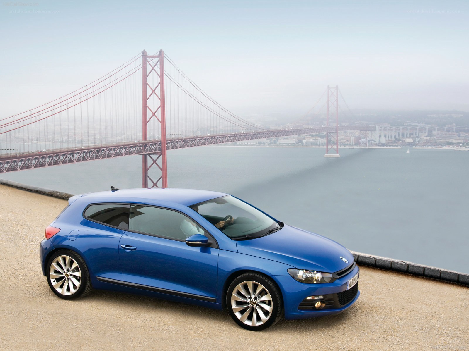 Blue Volkswagen Scirocco by a bridge