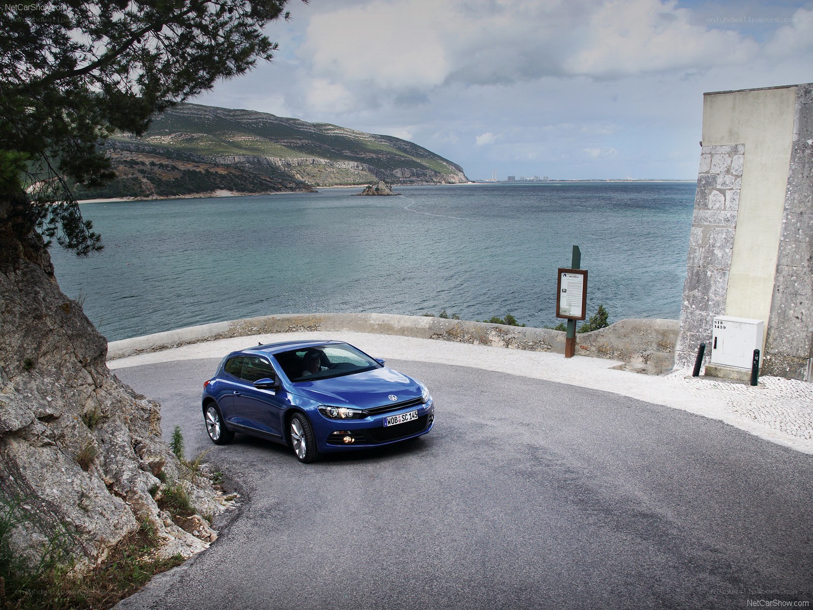 Blue Volkswagen Scirocco by the coast
