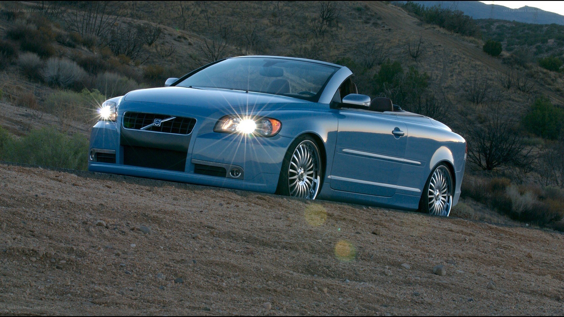 blue volvo convertible on hillside