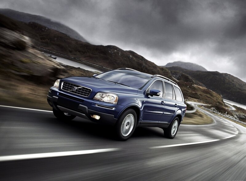 Blue Volvo driving on a winding road