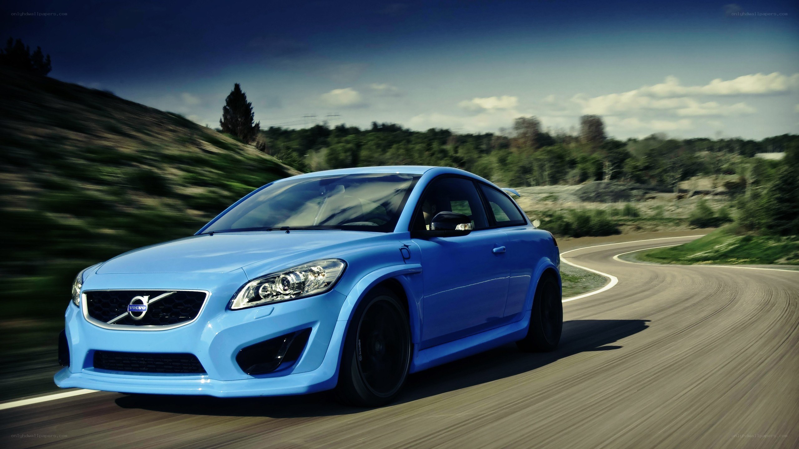 blue volvo on a winding road