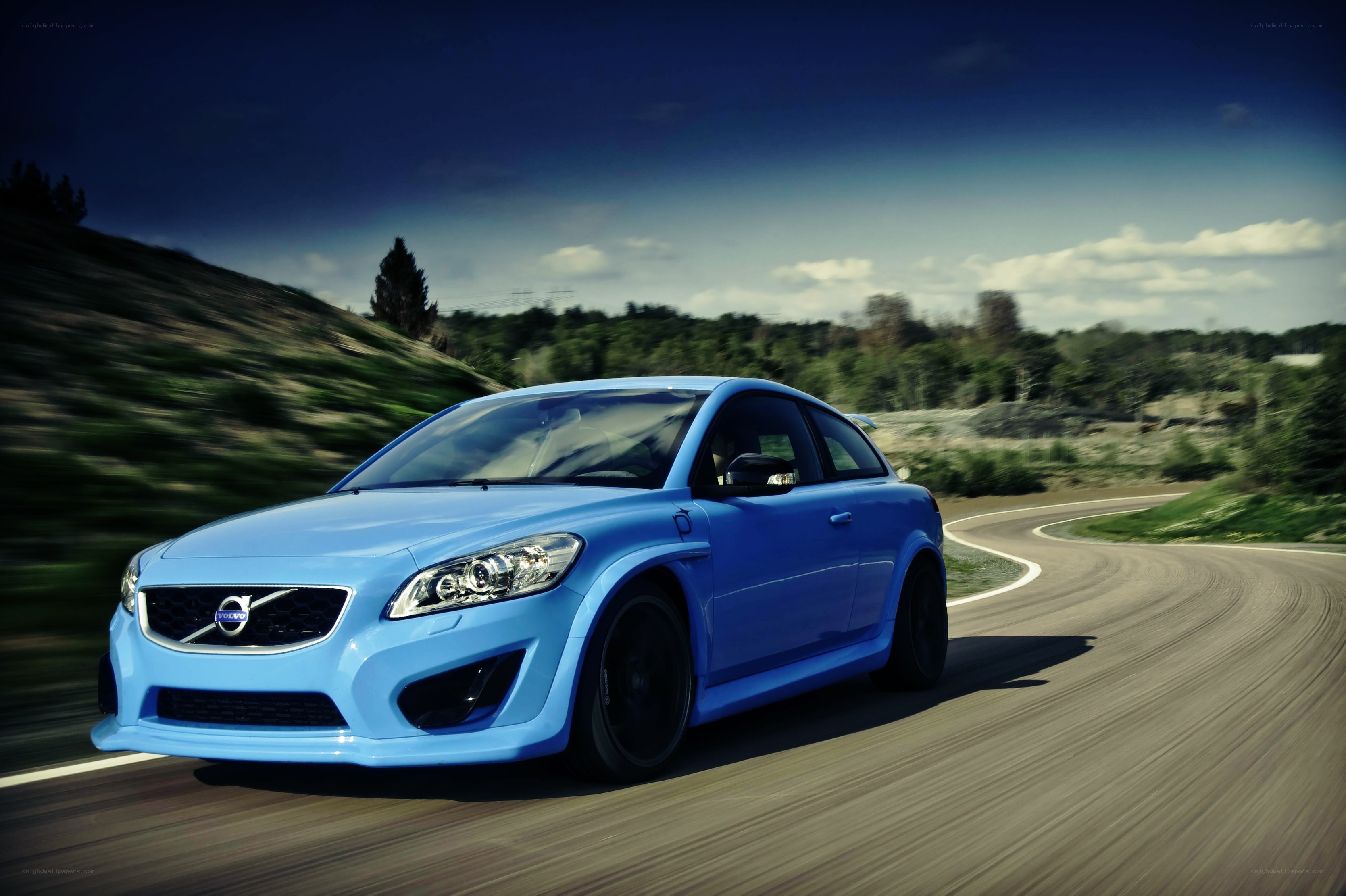 blue volvo on a winding road