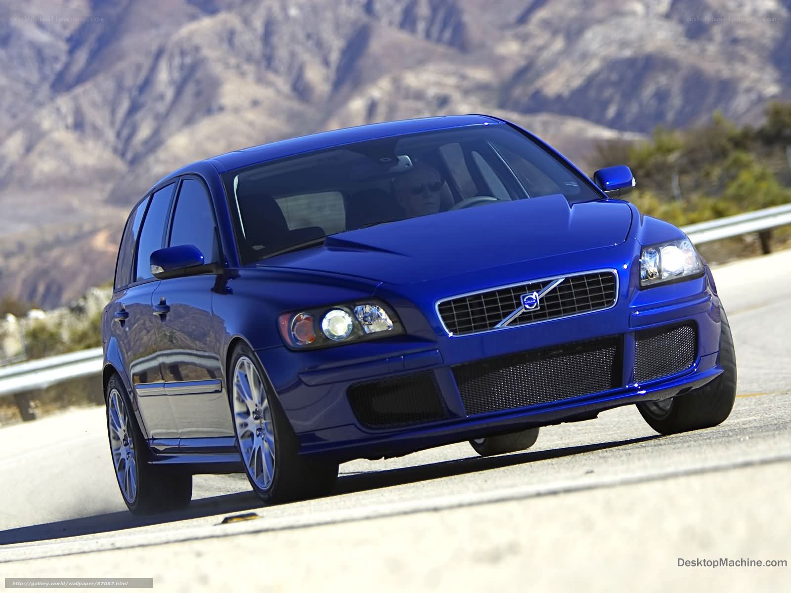 blue volvo on mountain road