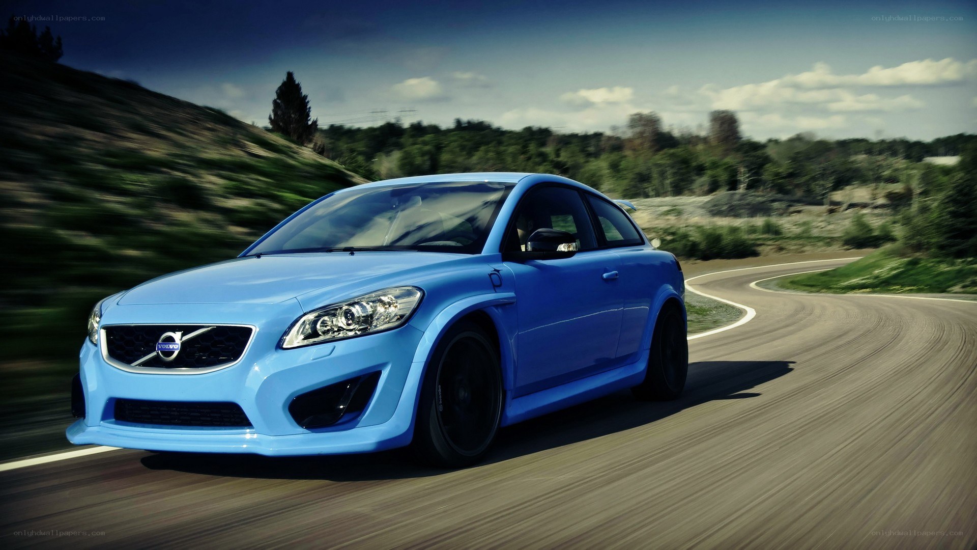 blue volvo on winding road