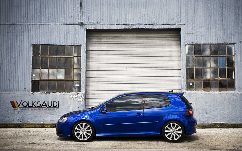 Blue VW Golf in front of warehouse