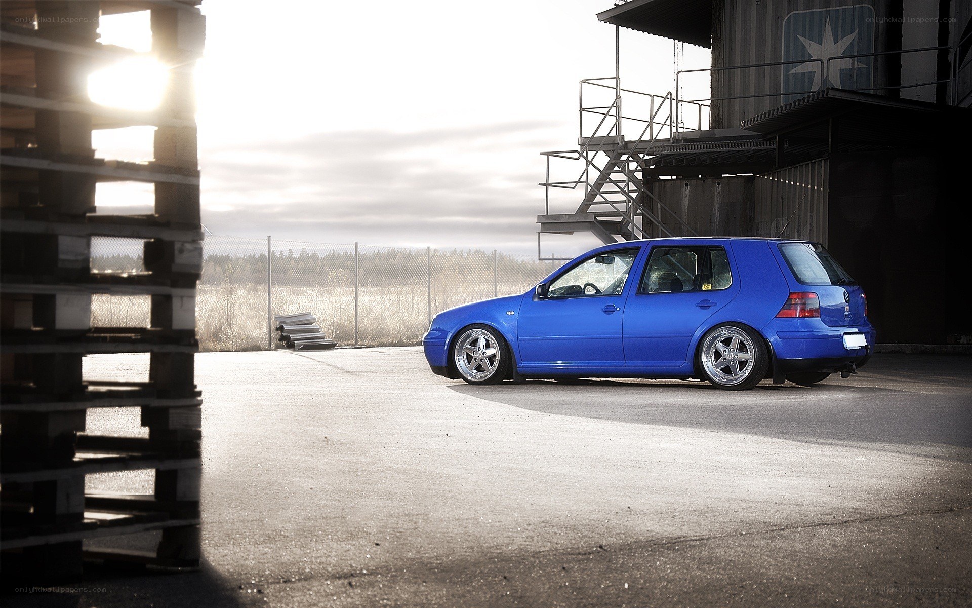 Blue VW Golf in industrial setting