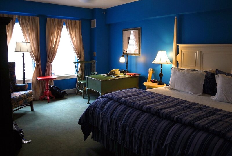 Blue-walled hotel room with bed and desk