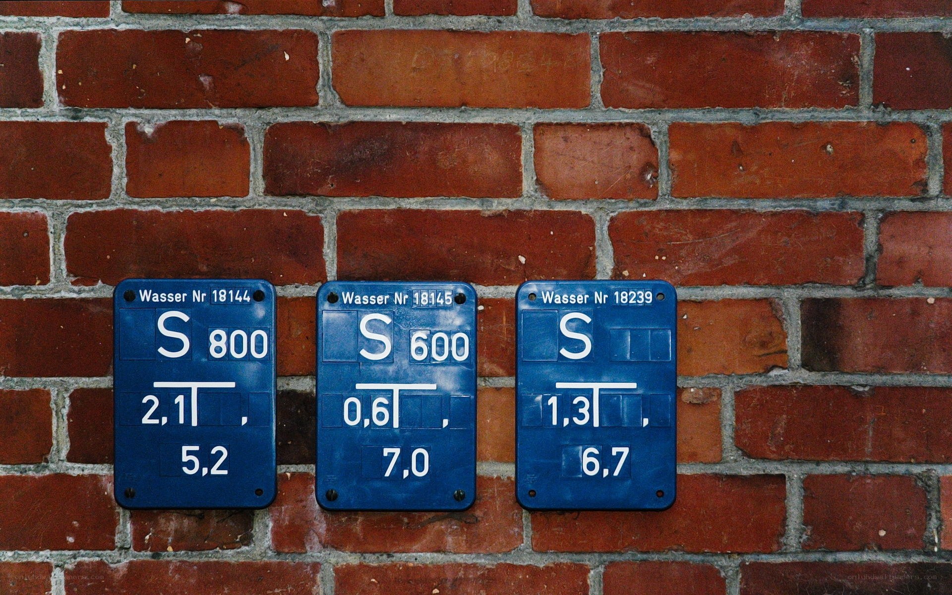 Blue water meters on brick wall