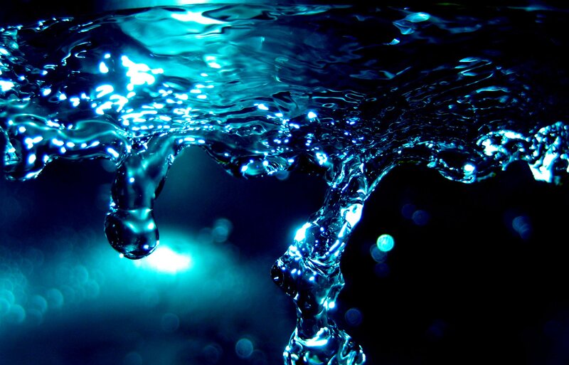 Blue water splash under light