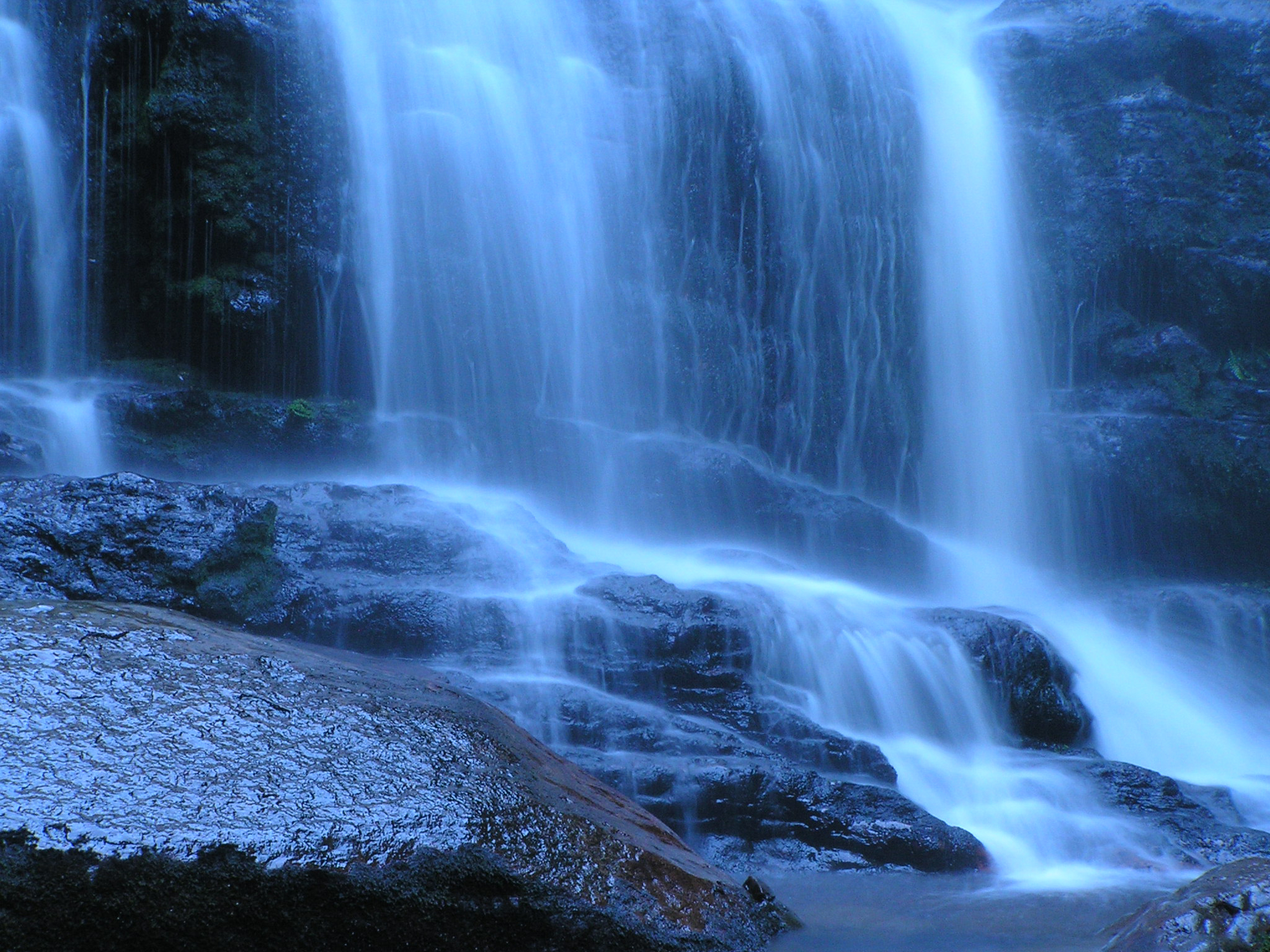 Blue waterfall cascading over rocks