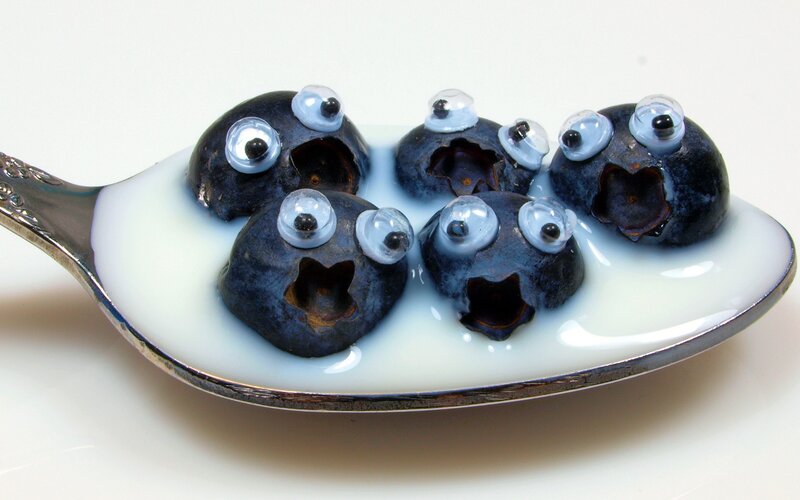 Blueberries with googly eyes on a spoon