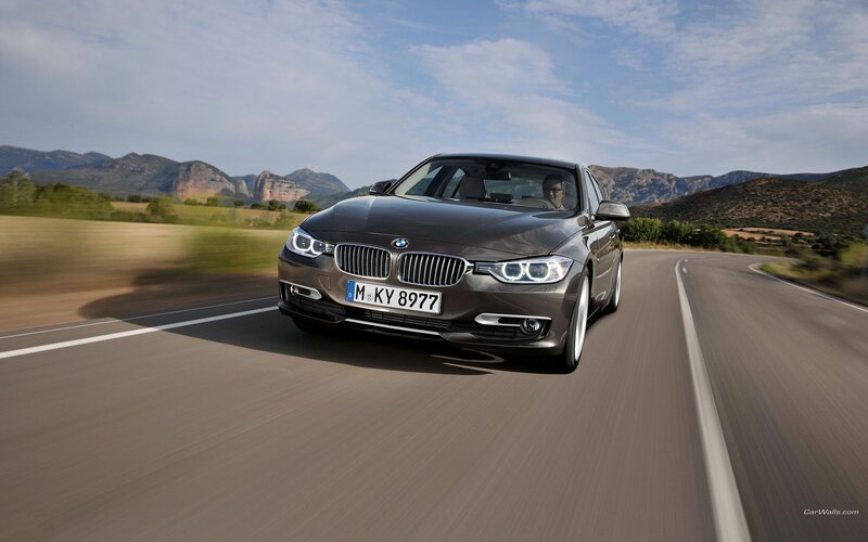 BMW 3 Series driving on a scenic road