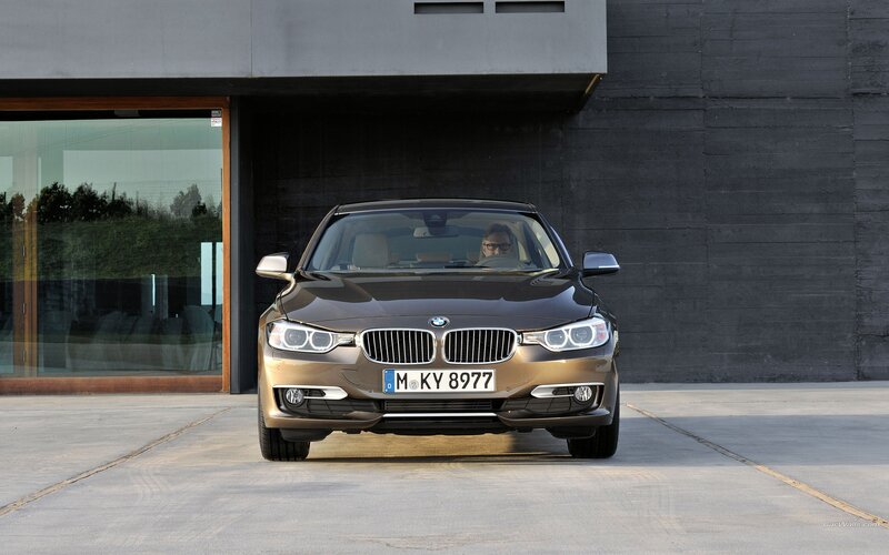 BMW 3 Series sedan in front of modern building