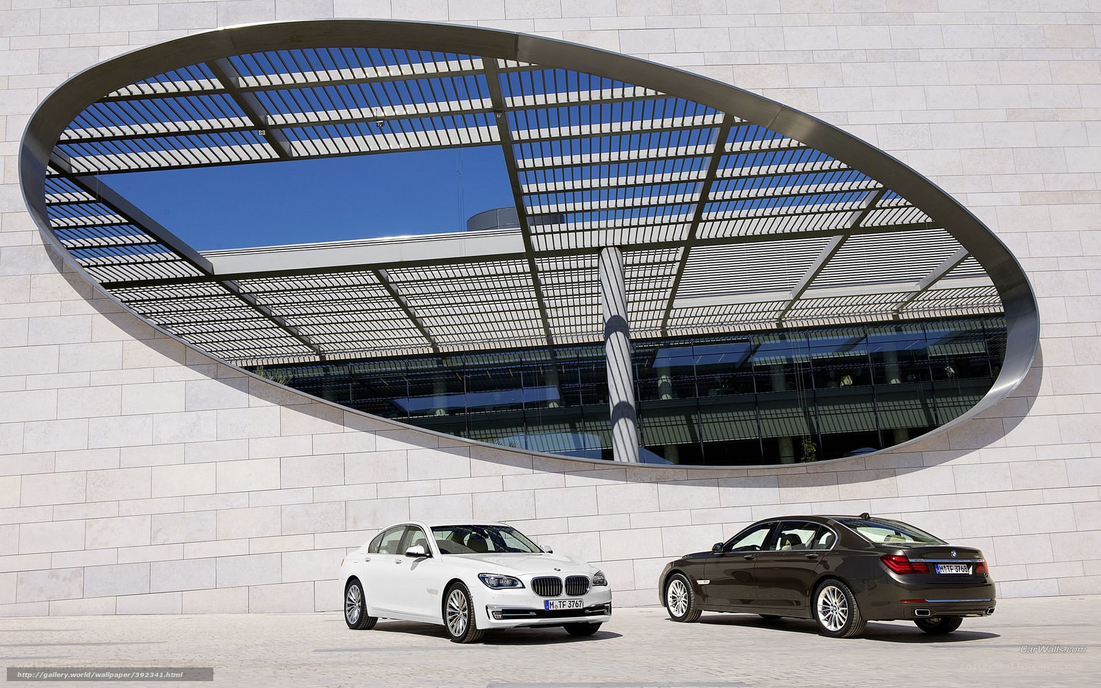 BMW 7 Series cars in front of modern building