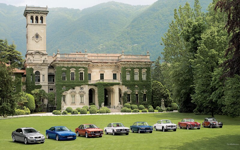 BMW cars in front of a mansion