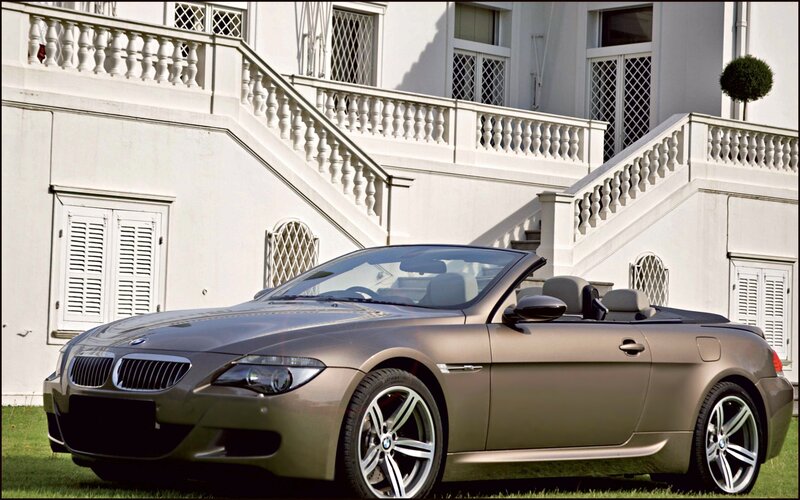 BMW convertible in front of mansion