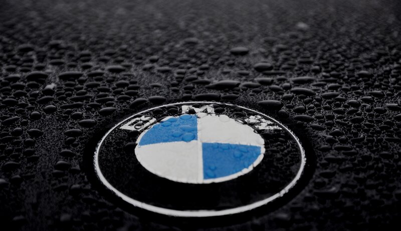 BMW Logo on Wet Surface — Black, Dramatic, Photograph