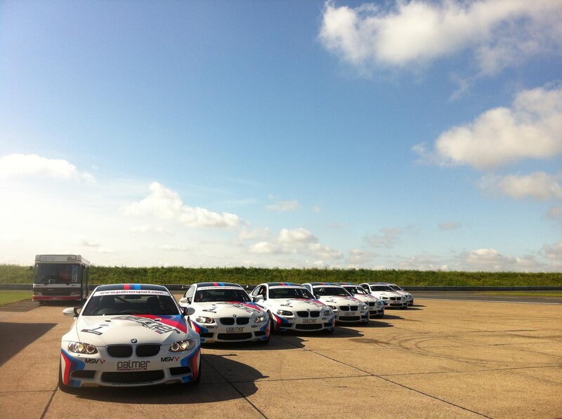 BMW race cars lined up at a track
