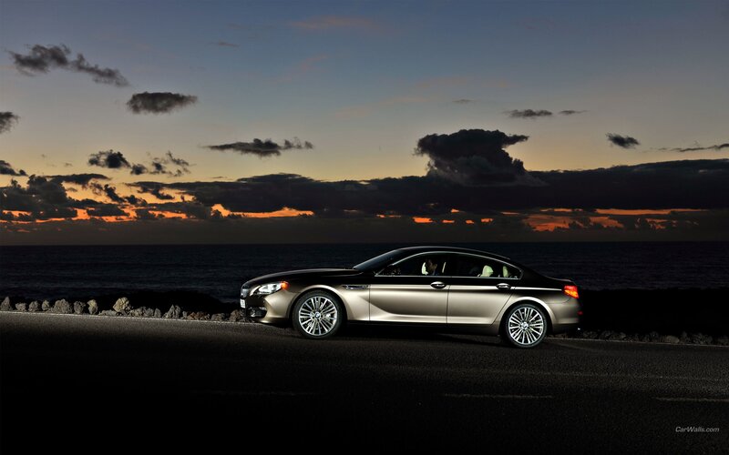 BMW sedan at sunset by the sea