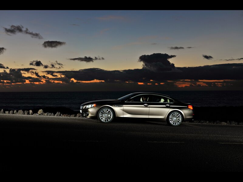 BMW sedan at sunset by the sea