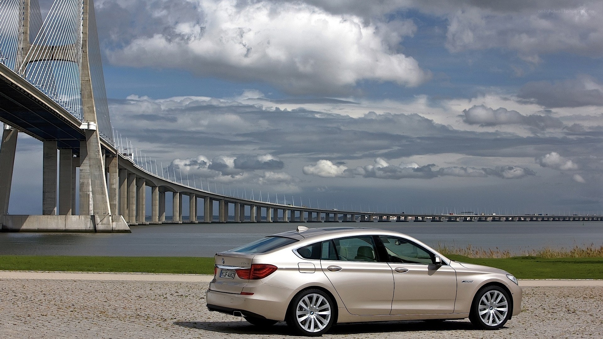 BMW sedan by a bridge
