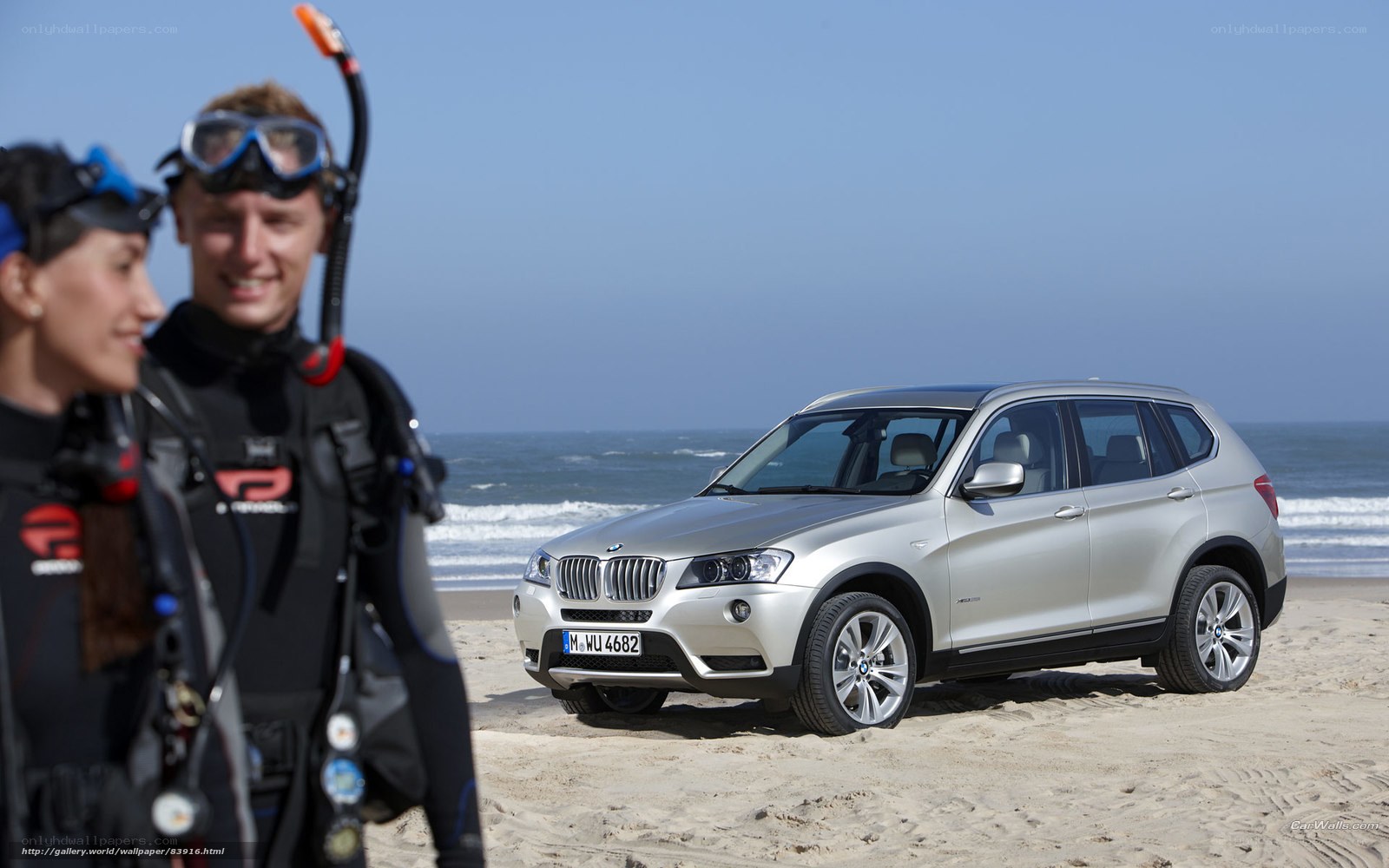 BMW X3 on a beach with divers
