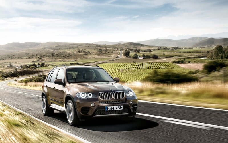 BMW X5 driving on a country road