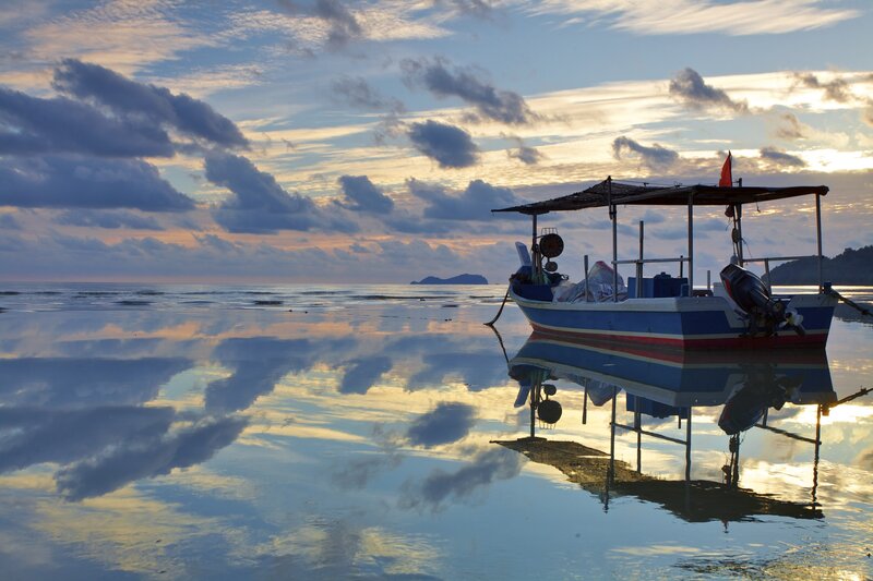 Boat at sunset on calm beach