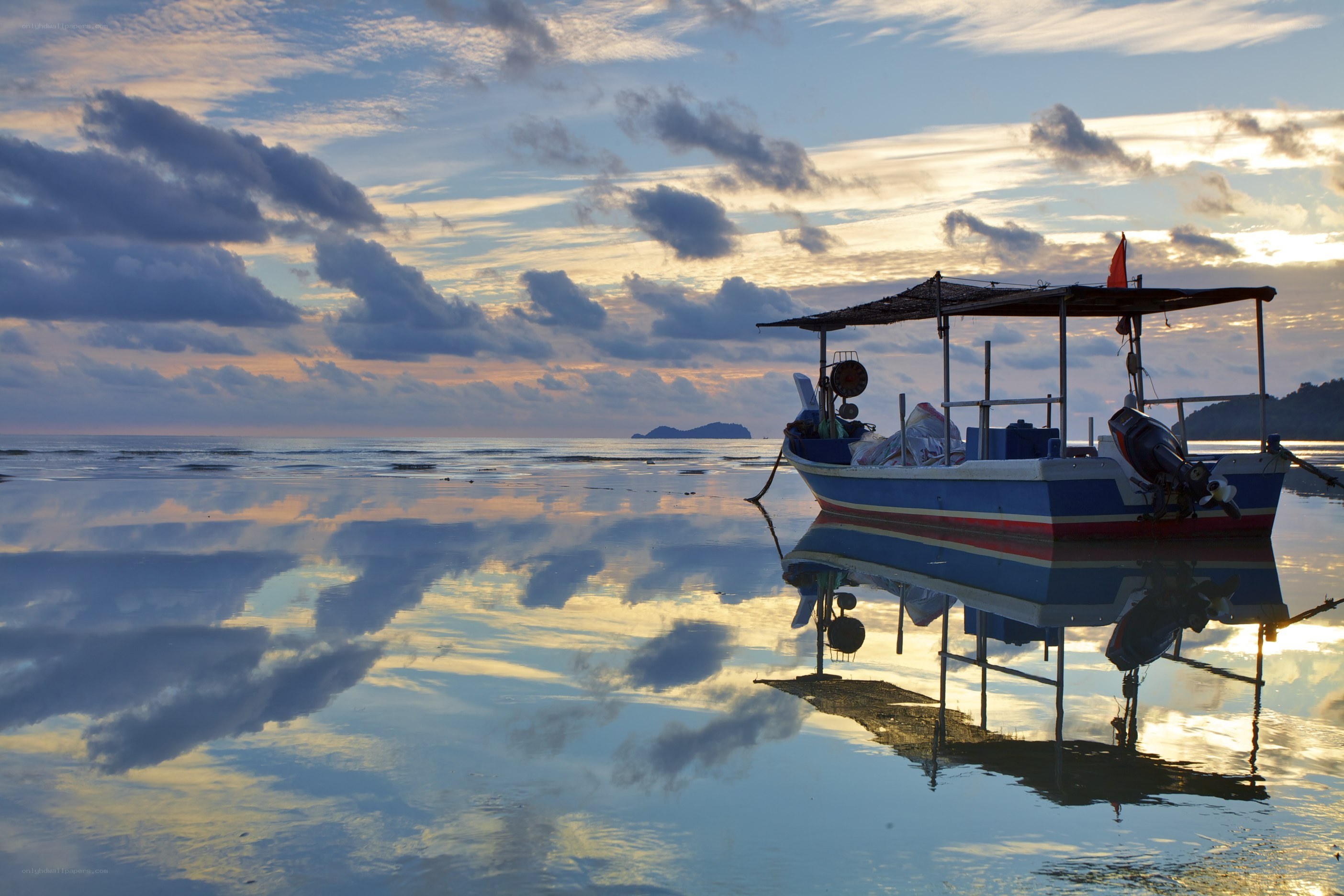 Boat at sunset on calm beach