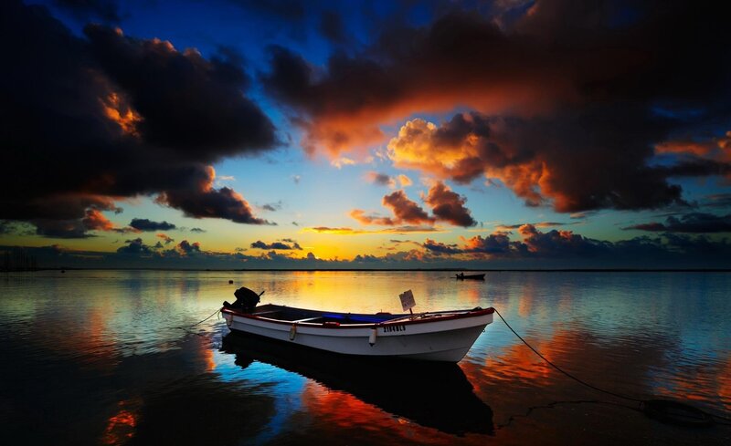 Boat at sunset on calm water