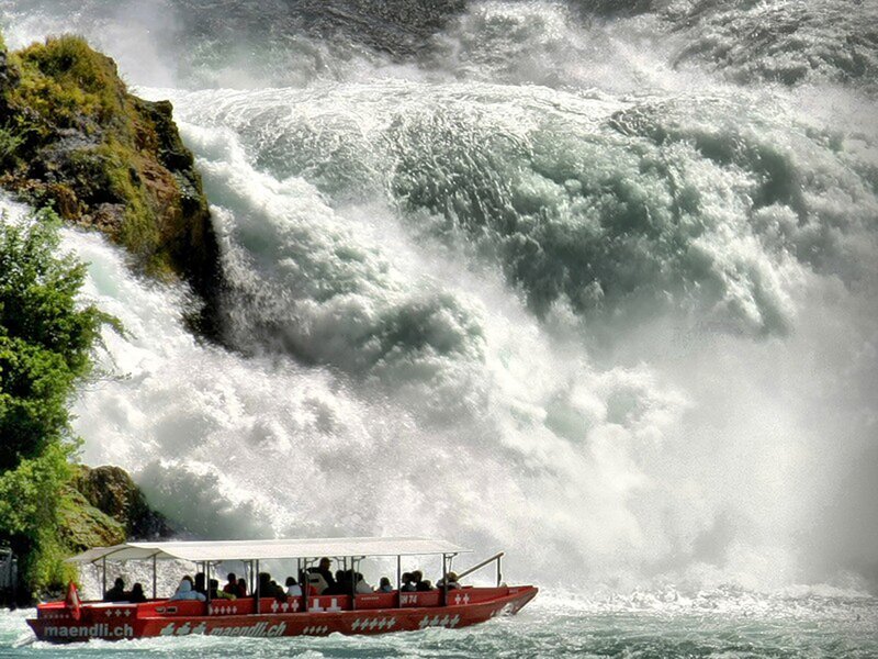 Boat near a powerful waterfall